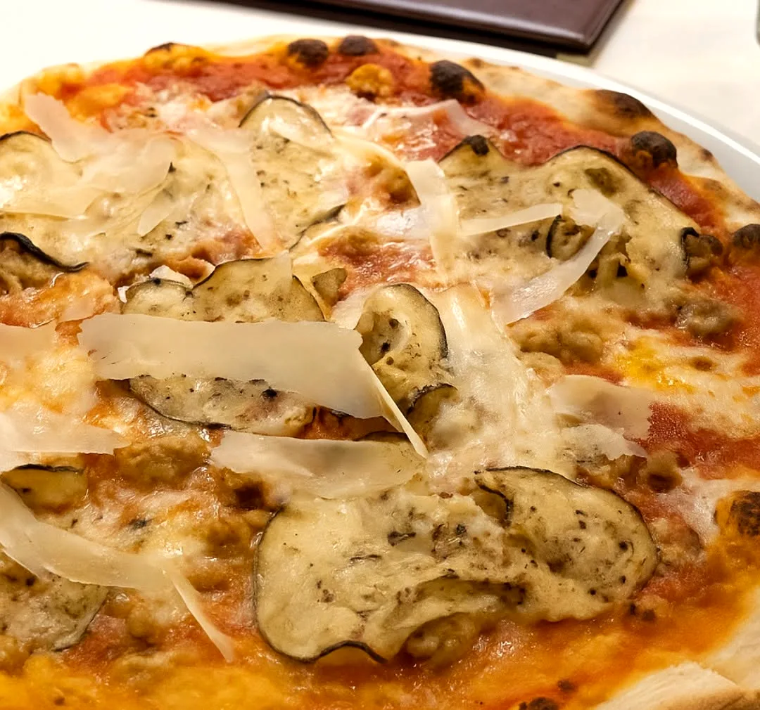 A white pizza layered with thin potato and shaved cheese